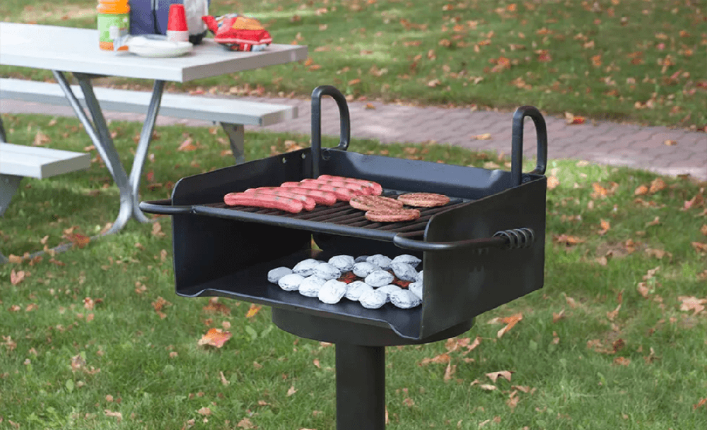 Commercial park grill installed on a pedestal in an outdoor pavilion overlooking a lake, designed for durable public use in parks and recreational areas